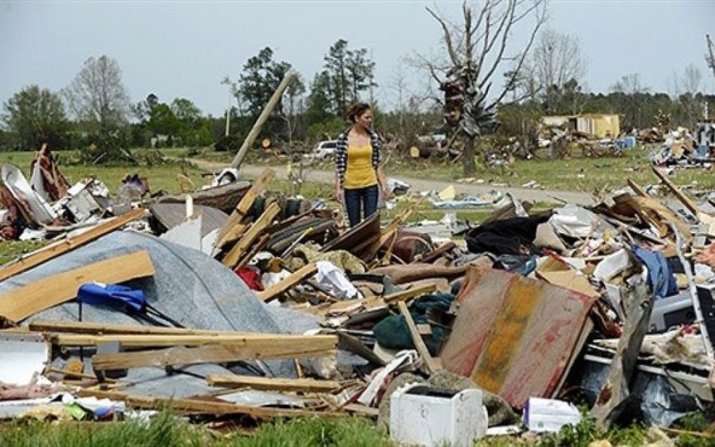 США, Аскьювілл. Жінка стоїть серед уламків свого будинку в місті Аскьювілл, Північна Кароліна. Торнадо, який пронісся над штатом, спричинив значні збитки. / © AFP