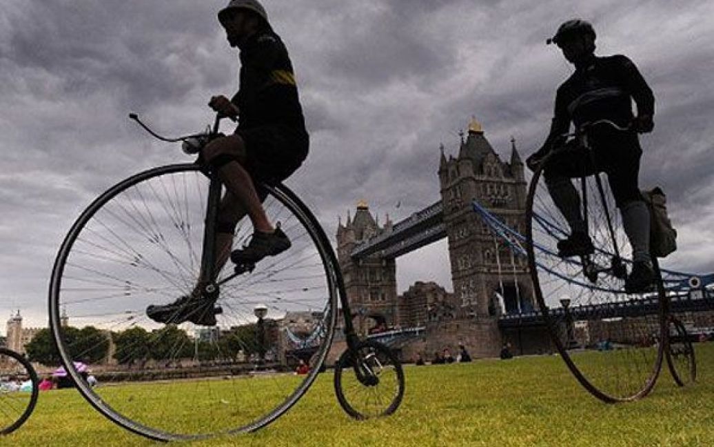 Великобританія, Лондон. Велосипедисти на старовинних велосипедах проїздять повз Тауерський міст в Лондоні. Велосипедисти змагатимуться за трофей "Брукс Ордінарі" під час 30-хвилинної гонки плюс 5 кіл навколо історичного ринку Smithfiled в Лондоні. / © AFP
