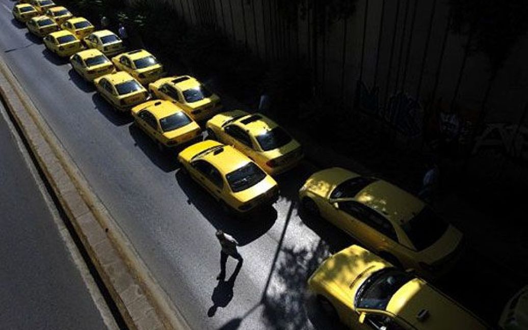 Греція, Афіни. Грецькі таксисти гуляють поруч зі своїми автомобілями, запаркованими уздовж дороги під час 24-годинного страйку в Афінах. / © AFP