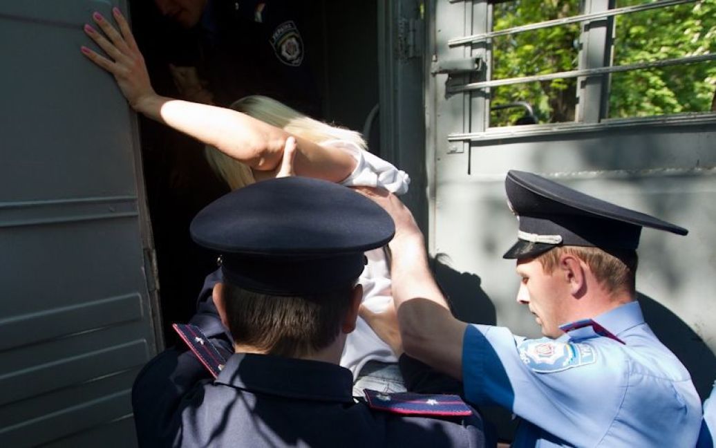 Через кілька секунд після початку топлес-акції протесту працівники міліції взяли дівчат за руки та ноги і віднесли до міліцейських автобусів. / © Жіночий рух FEMEN
