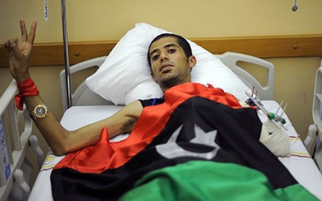 Лівійська Арабська Джамахірія, Бенгазі. Поранений лівійський повстанець показує знак перемоги, доки він лежить у лікарні після евакуації з міста Місрата. Вашингтон закликав Муаммара Каддафі провести переговори з повстанцями. / © AFP