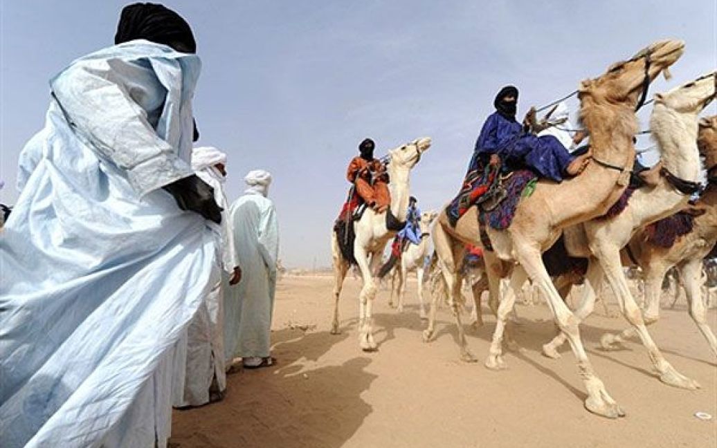 Алжир, Таманрассет. Чоловіки з племені туарегів йдуть верхи на верблюдах під час економічного фестивалю Assihar у Таманрассеті, на якому щороку туареги демонструють досягнення своєї культури: танці, традиційні ігри, роботи ремісників. / © AFP