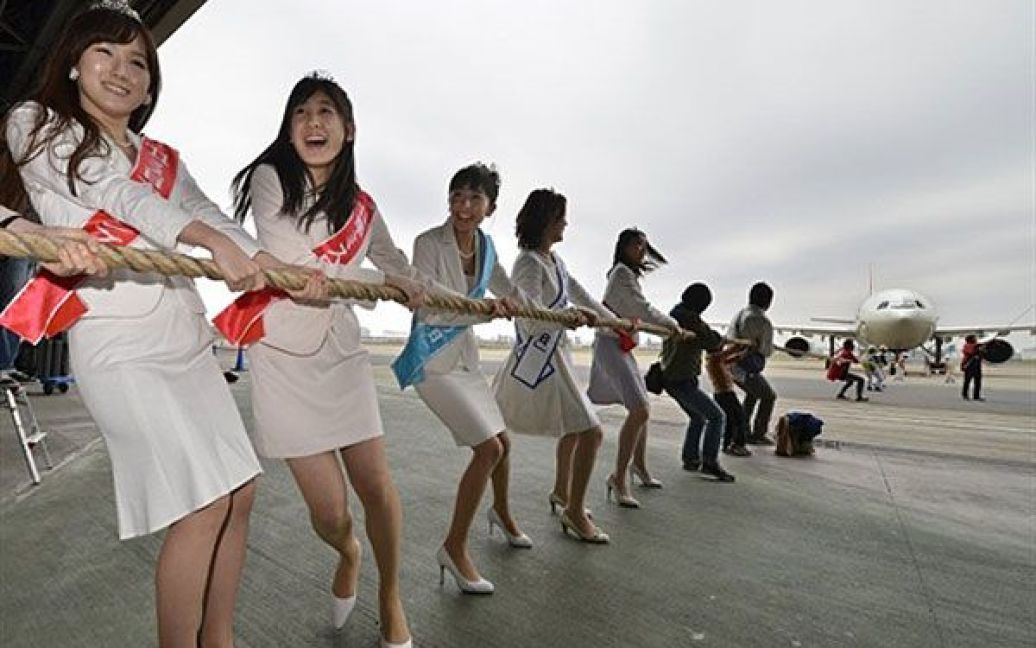 Японія, Токіо. Учасниці конкурсу краси "Міс Японія 2011" беруть участь у перетягуванні каната з 90-тонним літаком Airbus 300 авіакомпанії Japan Airlines в аеропорту Токіо під час святкування Дня дітей в Японії. / © AFP