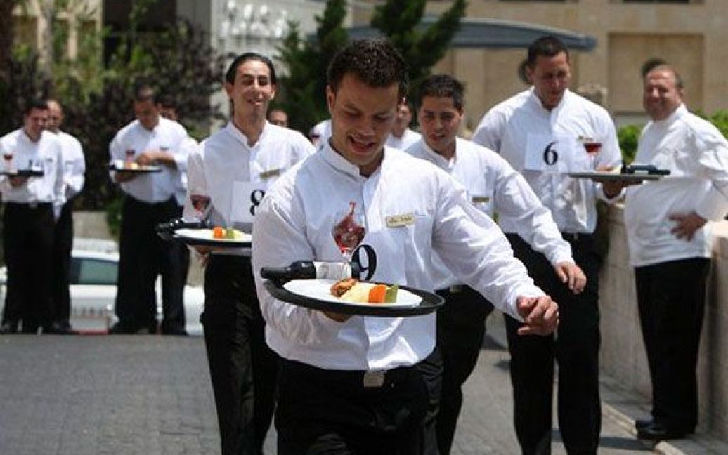 Єрусалим. Офіціанти готелю Гранд Корт беруть участь у гонці на 150 метрів, під час якої вони повинні були нести тацю з пляшкою вина, повну склянку і тарілку з їжею. / © AFP