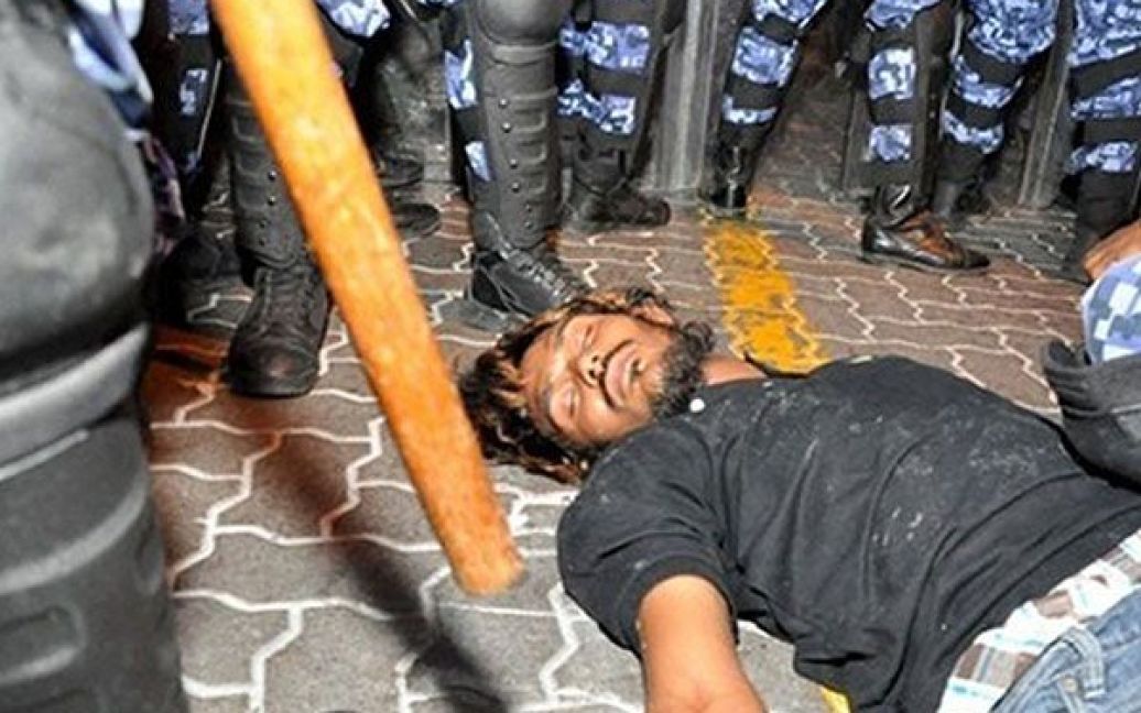 Мальдіви, Мейл. Мальдівский лідер опозиції Асад Алі Адубарі лежить на землі біля ніг ОМОНу під час вуличних протестів проти підвищення цін на Мальдівських островах. / © AFP