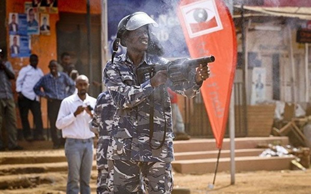 Уганда, Кампала. Поліцейський стріляє гранатами зі сльозогінним газом у демонстрантів під час заворушень, які спалахнули після мітингу в місті Кампала. Демонстранти вимагали не підвищувати ціни на продовольство і паливо. / © AFP