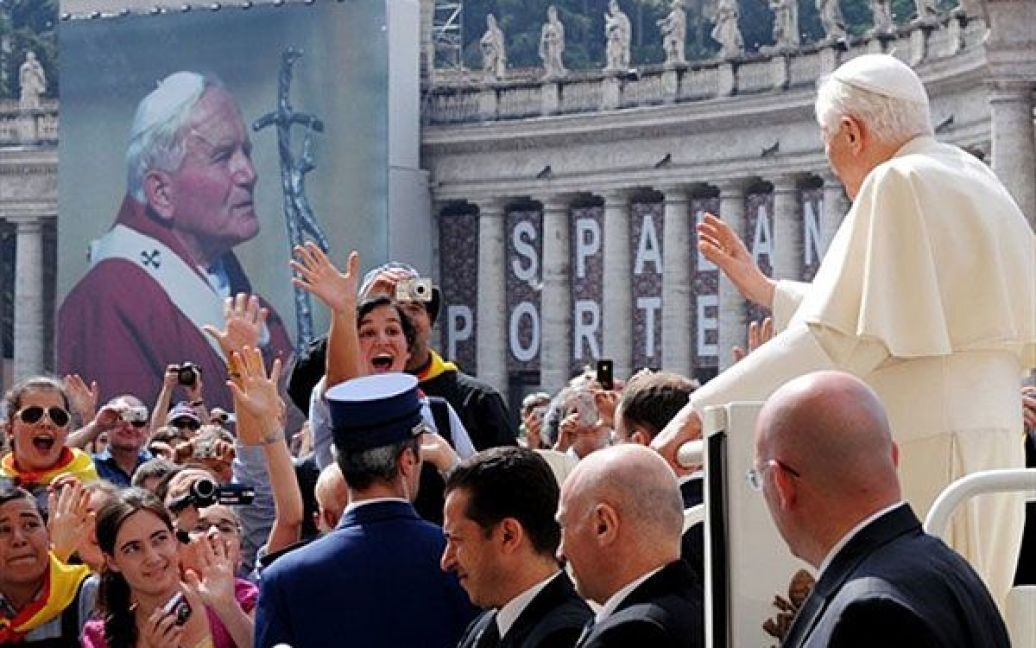 Ватикан. Папа Римський Бенедикт XVI вітає паломників, які зібрались перед великим плакатом із зображенням Папи Римського Іоанна Павла II, під час щотижневої загальної аудієнції на площі Святого Петра у Ватикані. / © AFP