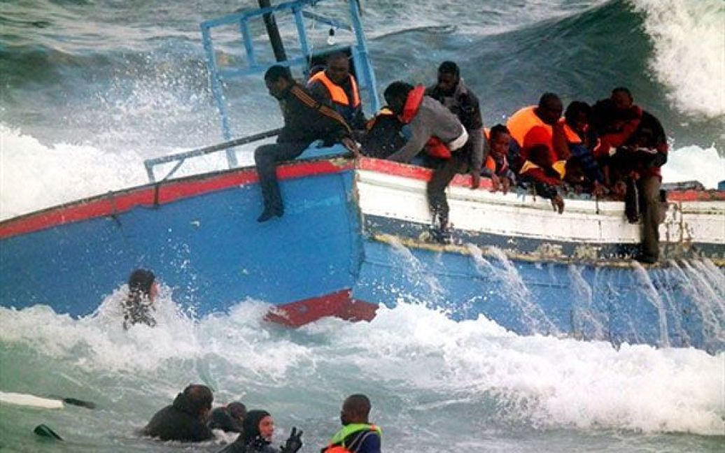 Італія, Пантеллерія. Рятувальники допомагають біженцям, які падають у море з човна, що врізався у скелі. Близько 250 мігрантів намагалися увійти в порт Пантеллерія на південному узбережжі Італії. / © AFP