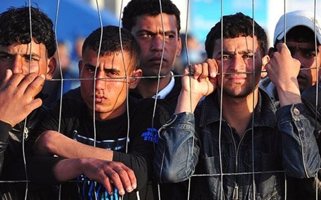 Італія, Лампедуза. Туніські мігранти чекають на прибуття човна на острові Лампедуза. Сотні тунісців були переміщені до наметових таборів на півдні Італії. / © AFP