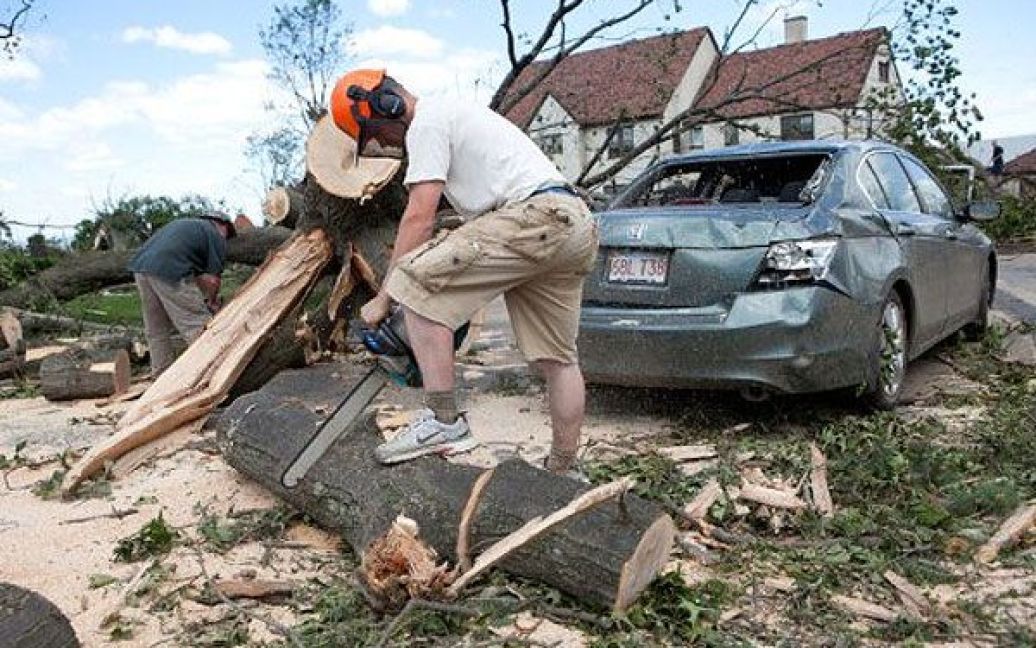США, Спрингфілд, штат Массачусетс. Робочий прибирає дерева, які були повалені торнадо на подвір&#039;ґ школи Макдаффі в Спрінгфілді. Торнадо обрушився на центральні та західні штати, заподіявши серйозної шкоди 18 містам, щонайменше 4 особи загинули. / © AFP