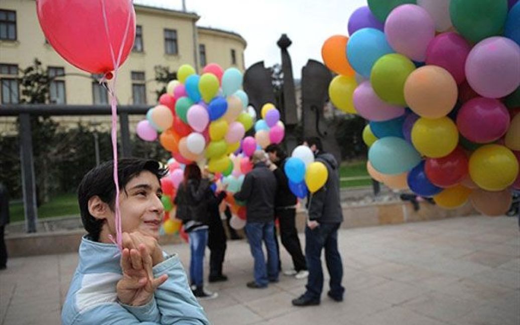 Румунія, Бухарест. Дитина-аутист посміхається під час мітингу, присвяченого Всесвітньому дню артистів. / © AFP