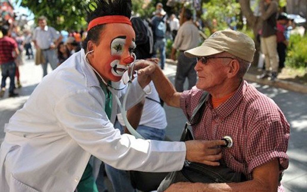 Гватемала, Гватемала. Клоун, одягнений як лікар, оглядає людину під час параду клоунів в історичному центрі міста Гватемала, де провели 3-ій Латиноамериканський конгрес колунів. / © AFP