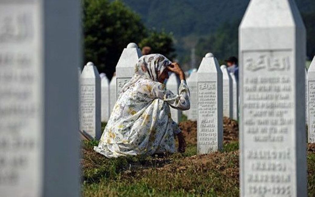 Боснія та Герцеговина, Сребрениця. Боснійська мусульманка сидить на могилі своїх родичів на меморіальному кладовищі Потоцарі поблизу Сребрениці. Цього року відзначаючи 16-річчя падіння Сребрениці, більше 4500 тіл були поховані в Сребрениці на  меморіальному кладовищі. / © AFP