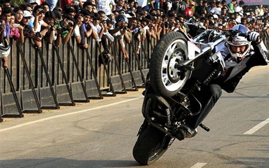 Індія, Бангалор. Вуличний стантер, мотоциклист Кріс Пфайфер виконує трюк на своєму мотоциклі BMW F800R під час шоу "Стріт Тур 2011". / © AFP