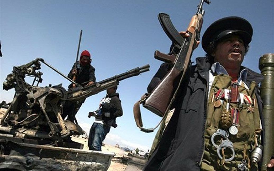 Лівійська Арабська Джамахірія, Брега. Лівійські повстанці роздивляються один з двох знищених авіаударом НАТО пікапів, які належали силам, лояльним до лівійського лідера Муаммара Каддафі. / © AFP