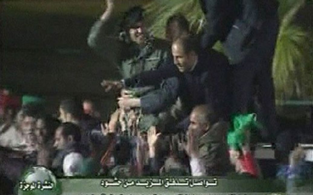 Лівійська Арабська Джамахірія, Тріполі. Державне телебачення Лівії нібито показало Хаміса, сина лівійського лідера Муаммара Каддафі, який вітає натовп військових за межами своєї резиденції у Тріполі, щоб скасувати чутки про його смерть. Фото AFP/LIBYAN TV / © 