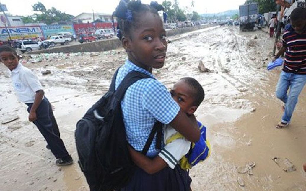 Гаїті, Порт-о-Пренс. Діти йдуть до школи затопленими вулицями міста Порт-о-Пренс. Проливні дощі спричинили на Гаїті повені, підтоплення нетрів, які встигли звести після землетрусів 2010 року. Щонайменше 10 осіб загинули. / © AFP