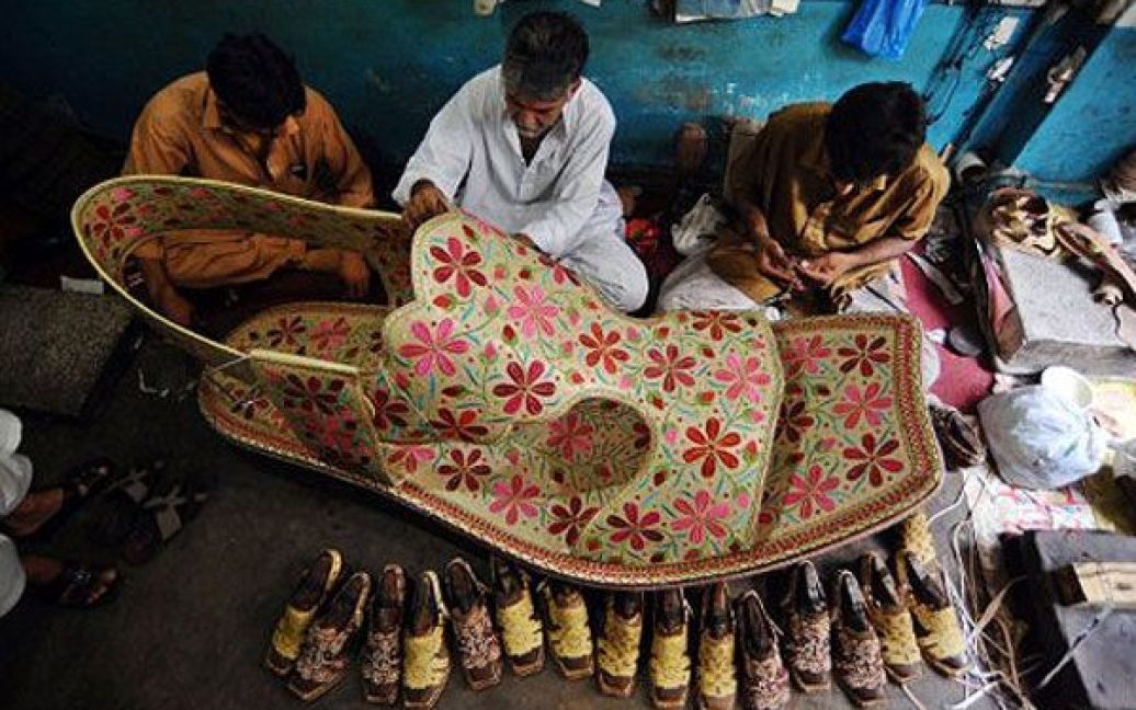 Пакистан, Лахор. Пакистанські виробники взуття працюють над створенням гігантського черевика. Розмір черевика, вишитого золотою ниткою, становить майже два метри, ціна &mdash; близько 350 доларів США. / © AFP