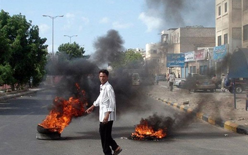 Ємен, Аден. Єменець проходить повз палаючі шини після антиурядових протестів у місті Аден, під час яких були вбиті 2 людини і поранені 4 людини. Військові відкрили вогонь по демонстрантах, які намагалися заблокувати дороги в місті для загального страйку. / © AFP