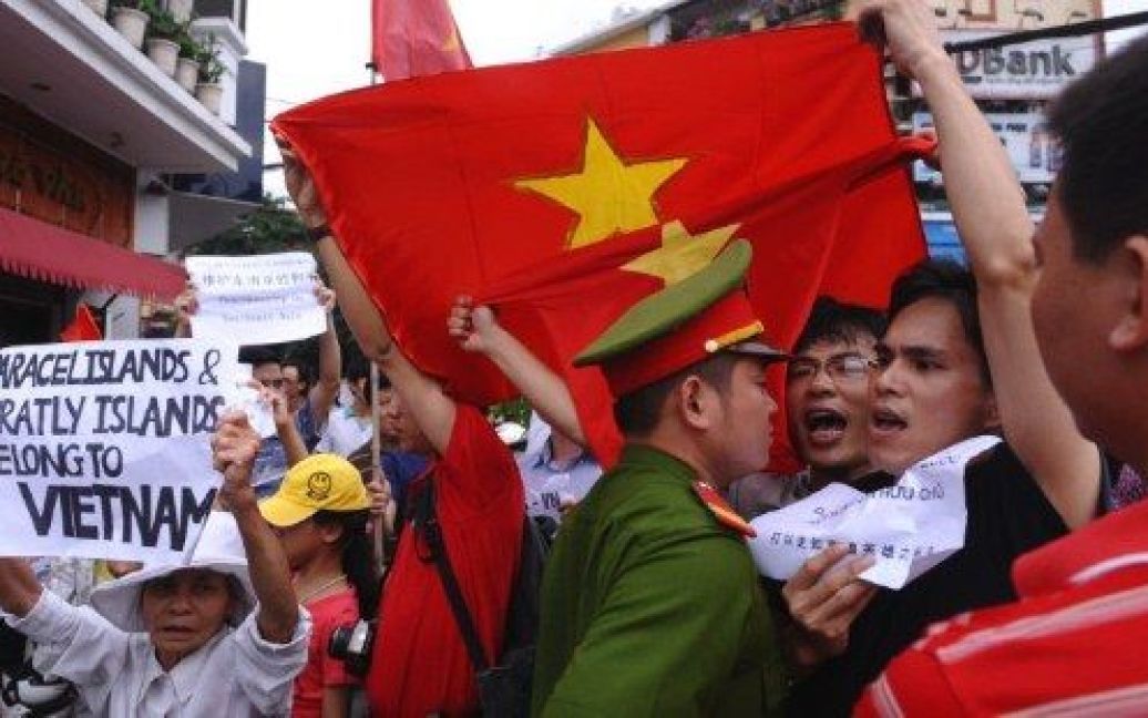 В&#039;єтнам, Ханой. Демонстранти вигукують антикитайські гасла поряд з поліцейським під час маршу протесту в центрі міста Ханой. Люди вийшли на вулиці на знак протесту проти територіальної суперечки навколо групи островів у Південно-Китайському морі. / © AFP