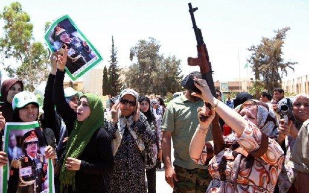 Лівійська Арабська Джамагирія, Бані Валід. Лівійські жінки тримають портрети лідера Муаммара Каддафі та бойову зброю під час військових навчань для жінок в області Бані Валід поблизу Тріполі. / © AFP