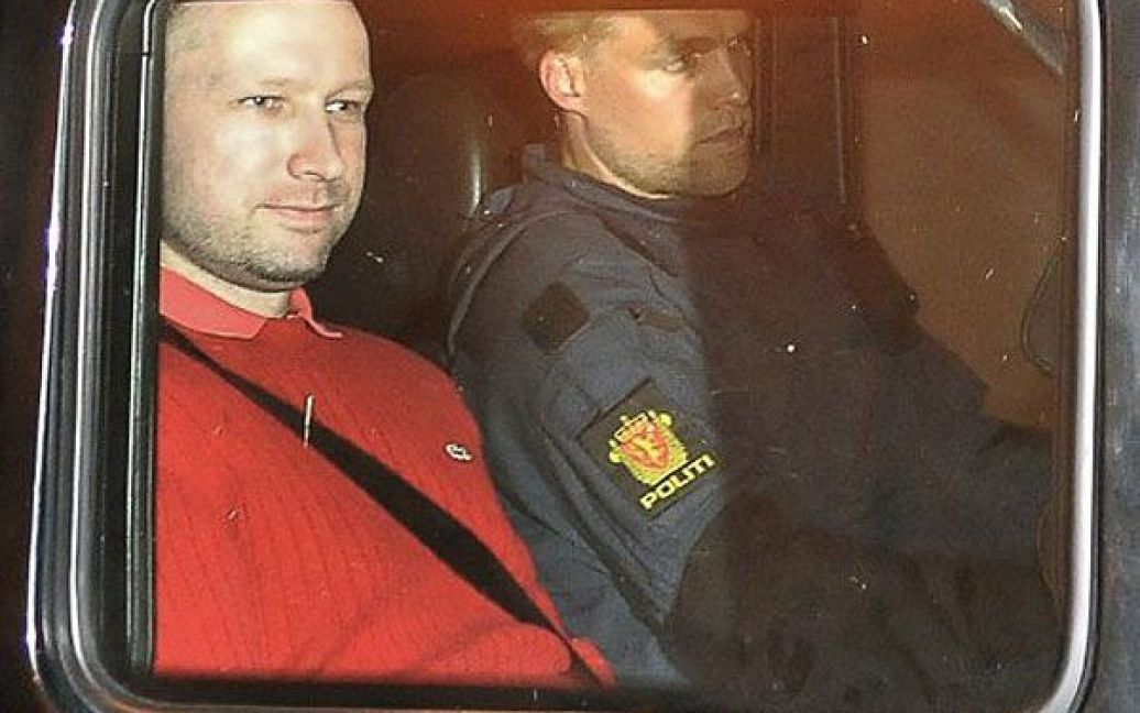 Норвегія, Осло. Підозрюваного у скоєнні подвійного теракту в Норвегії Андерса Берінга Брейвіка (у червоному) вивозять з будівлі суду в поліцейській машині. Суд вирішив надалі утримувати Брйевіка під вартою, він проведе у одиночній камері перші чотири тижні, із повною забороною на спілкування з зовнішнім світом. / © AFP