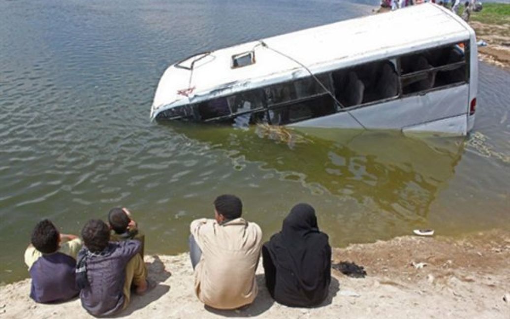 Єгипет, Бані Суейф. Місцеві жителі дивляться на мікроавтобус, який впав у Ніл. В результаті аварії загинули 22 людей. / © AFP
