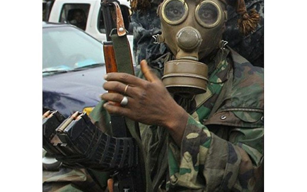 Кот-д&#039;Івуар, Абіджан. Прихильник Алассана Уаттара з Республіканських сил Кот-д&#039;Івуара у протигазі, готується до "останнього штурму" в Абіджані. Кандидат у президенти Кот-д&#039;Івуара Лоран Гбагбо заховався в бункері у своїй резиденції в Абіджані. / © AFP