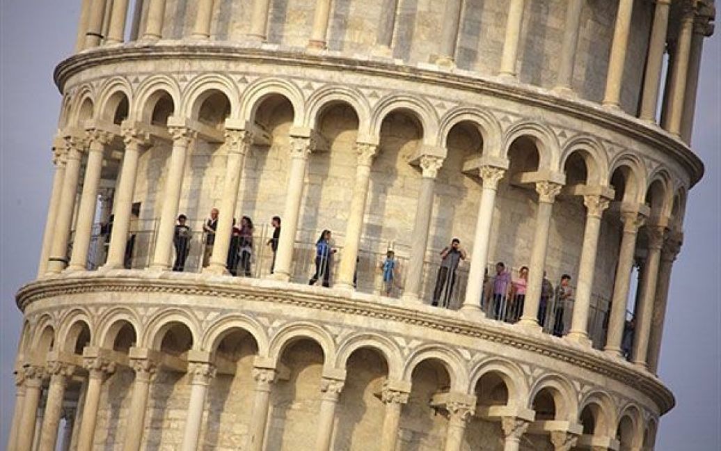 Італія, Піза. Туристи відвідають Пізанську вежу, яку, вперше після 20 років стабілізації і реставраційних робіт, звільнили від будівельних лісів. Будівництво вежі було розпочато у 1173 році. Хоча архітектори та інженери намагалися стабілізувати вежу з тих пір, вона продовжувала нахилятися. / © AFP