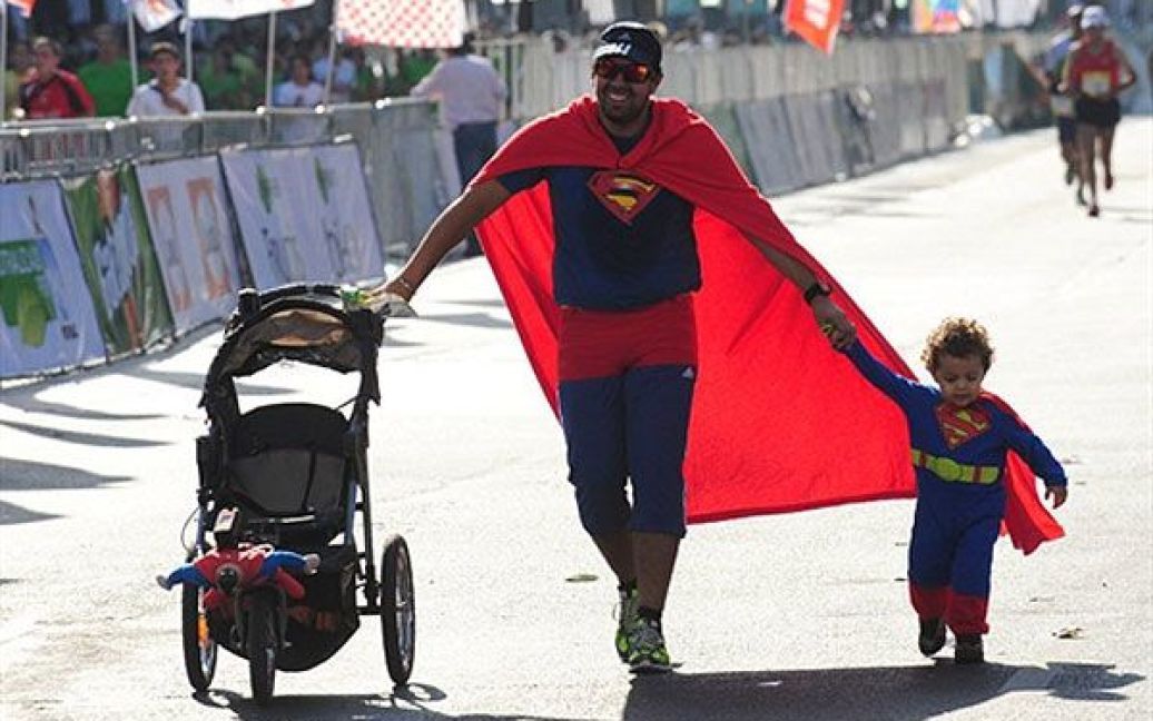 Чилі, Сантьяго. Чоловік із сином, одягнені у костюми Суперменів, беруть участь у 5-му марафоні Сантьяго. / © AFP