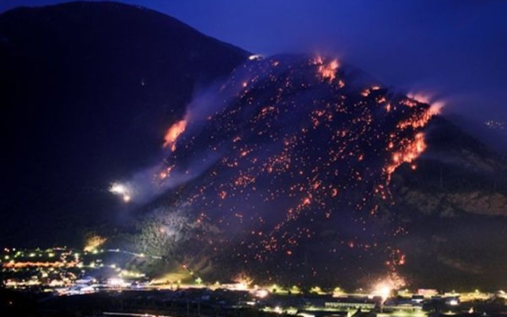 Швейцарія, Вале. Найбільші за останні 150 років лісові пожежі охопили кантон Вале. Через сильну посуху пожежа швидко перекинулася з автомобіля, що палав на узбіччі, до лісу. У операції з ліквідації пожеж беруть участь 300 рятувальників та 9 вертольотів. / © AFP
