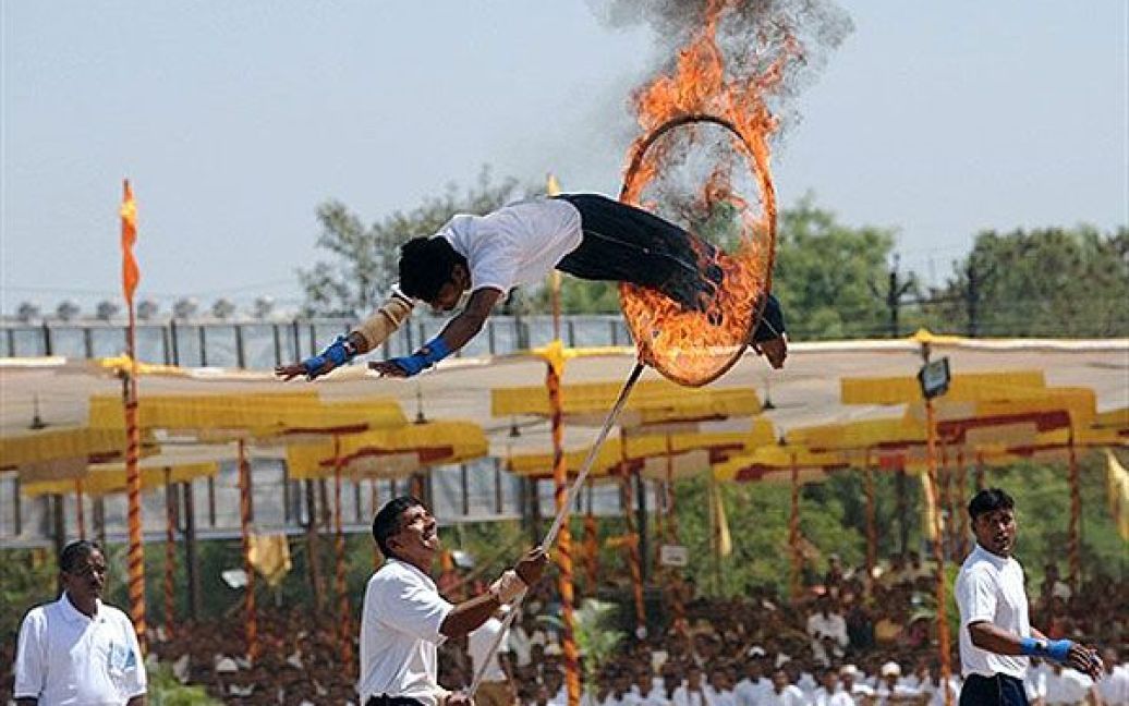Індія, Ананд. Поліцейський стрибає через палаючий обруч під час виступу в місті Ананд. Поліція Гуджарату провела демонстрацію своїх навичок "Надзвичайний стан 108". / © AFP