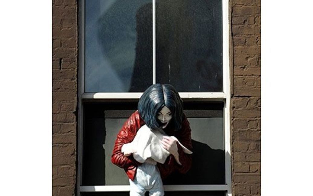 Великобританія, Лондон. Інсталяція "Мадонна з немовлям" шведського художника Мариї фон Келер представляє співака Майкла Джексона, який звісився з вікна із дитиною в руках. Ця скульптура Майкла Джексона викликала гнів фанатів короля поп-музики. / © AFP