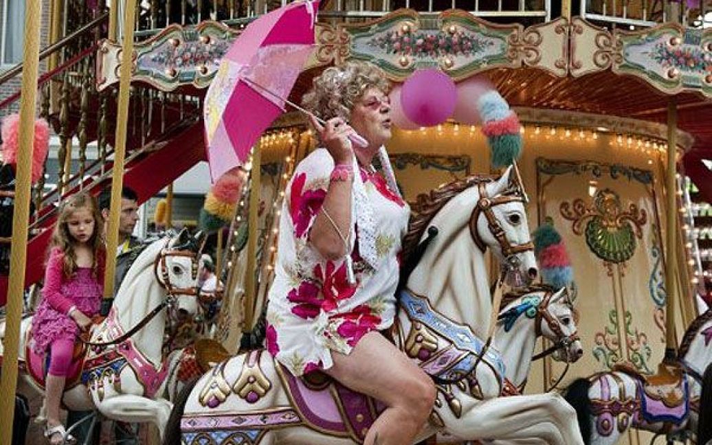 Нідерланди, Тілбург. Люди катаються на каруселі під час участі в 20-му щорічному ярмарку "Рожевий понеділок". Тисячі геїв, лесбіянок, бісексуалів і трансгендерів з усього світу щороку збираються на гей-ярмарок "Рожевий понеділок" в Тілбурзі. / © AFP