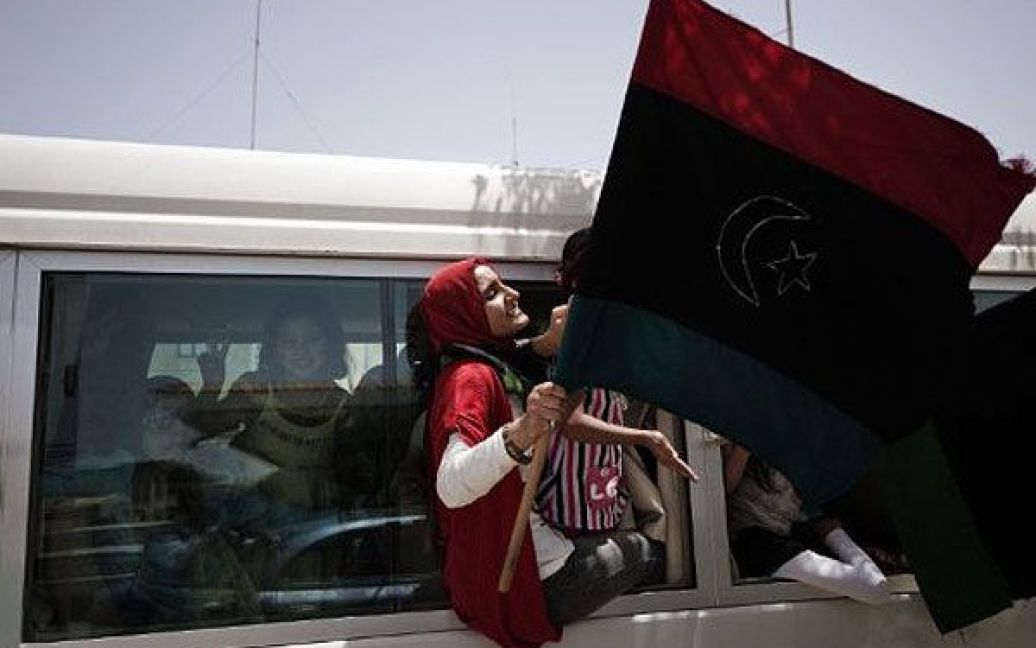 Лівійська Арабська Джамахірія, Бенгазі. Лівійські жінки розмахують національними прапорами та вигукують гасла повстанців проти лідера Муаммара Каддафі під час маршу лівійським містом Бенгазі, оплотом повстанського руху в Лівії. / © AFP