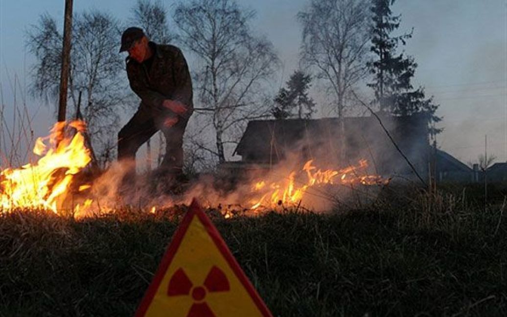 Білорусь, Рудноє. Чоловік контролює вогонь під час підготовки парового поля у покинутому селі Рудноє у 30-кілометровій зоні відчуження навколо Чорнобильської АЕС. / © AFP
