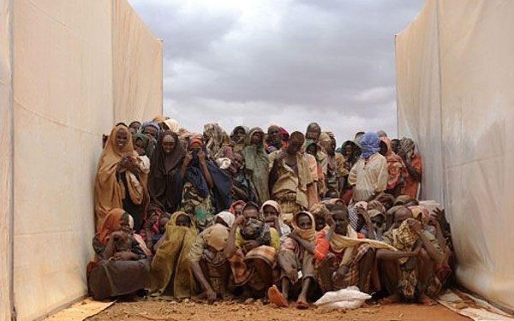 Ефіопія, табір Кобе. Сомалійські біженці, які нещодавно перетнули кордон із Сомалі, чекають на їжу, сидячи між двома наметами у таборі біженців Кобе. ООН офіційно оголосила про голод на півдні Сомалі через найбільш спустошливу посуху в Африці за останні 60 років. / © AFP