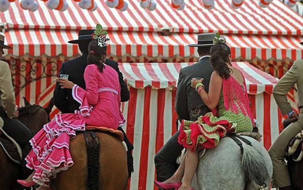 Іспанія, Севілья. Люди у традиційному андалузькому одязі беруть участь у відомому квітневому севільському ярмарку, який вперше провели у 1847 році, як ярмарок худоби. Пізніше ярмарок перетворився на щорічний тиждень фламенко, музики та кориди. / © AFP