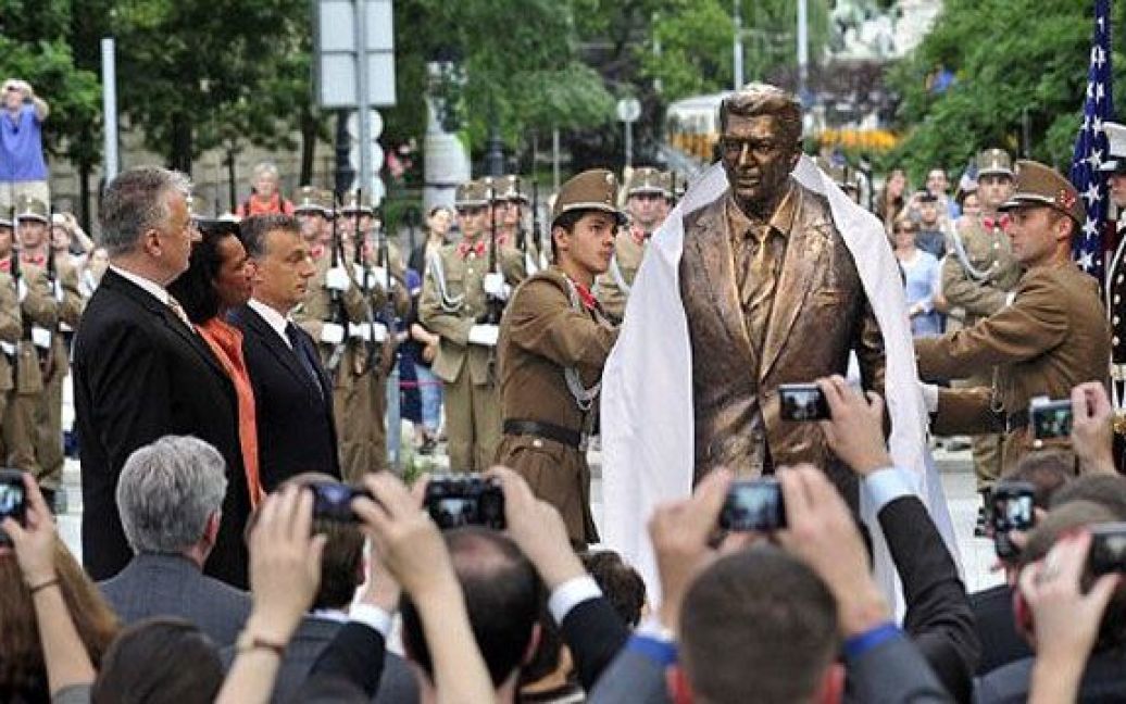 Угорщина, Будапешт. Прем&#039;єр-міністр Угорщини Віктор Орбан і колишній держсекретар США Кондоліза Райс стоять поруч зі статуєю президента США Рональда Рейгана на площі Свободи. В Будапешті відкрили бронзову статує Рейгану вагою 180 кг і висотою 2,18 м на честь 100-річчя покійного президента. / © AFP