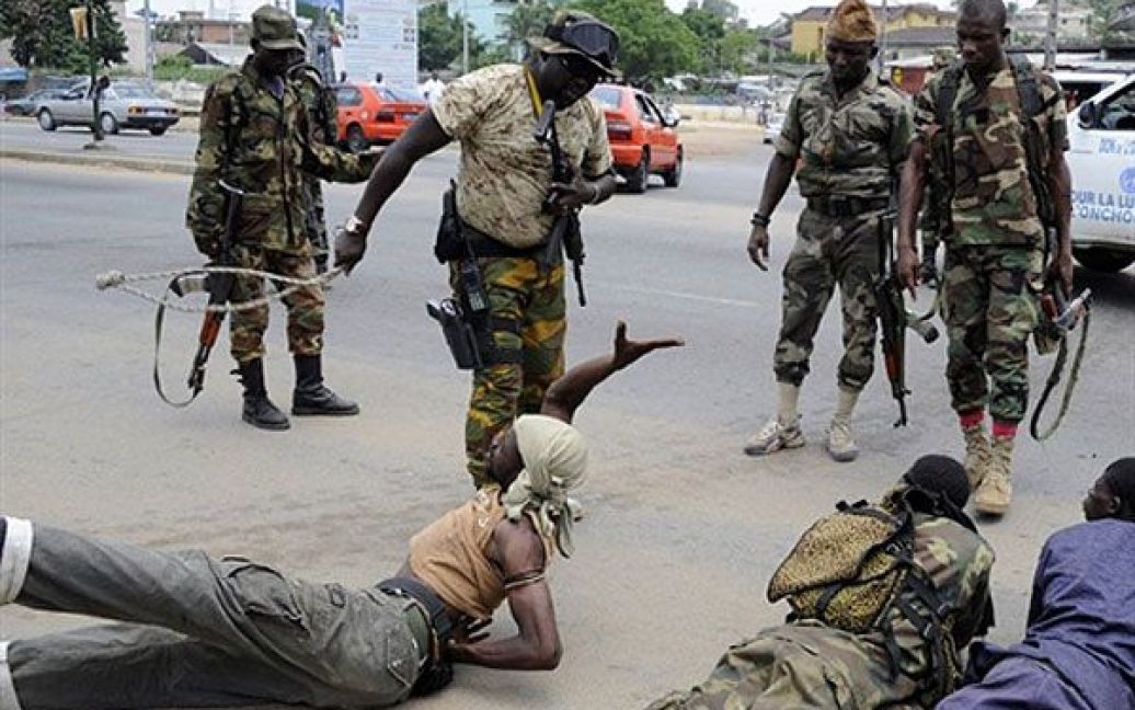 Кот-д&#039;Івуар, Абіджан. Поліцейський б&#039;є чоловіка, якого звинувачують у пограбуваннях в Абіджані. Алассана Уаттара прийшов до влади в країні після того, як його суперника Лорана Гбагбо було затримано. / © AFP