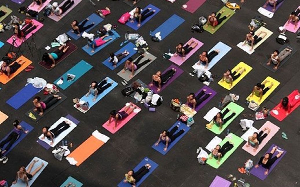 Китай, Гонконг. Люди виконують вправи йоги під час "Йогатону" (Yogathon) в Гонконгу, де провели восьмигодинне безперервне тренування, щоб зібрати гроші для Фонду раку молочної залози. / © AFP