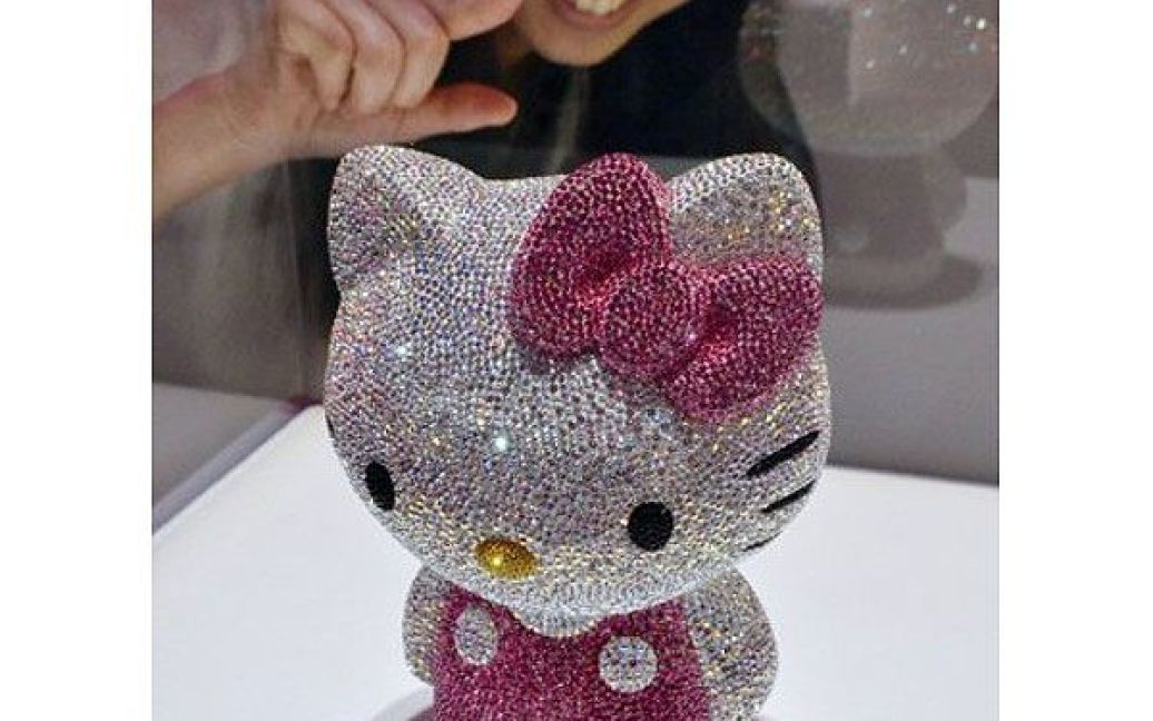 Японія, Токіо. Дівчина роздивляється ляльку "Hello Kitty", оздоблену 19 636 кристалами Swarovski, під час прес-показу колекції Swarovski в Токіо. Статуетки, яких було виготовлено 88 штук, будуть продаватися за 14500 доларів США. / © AFP