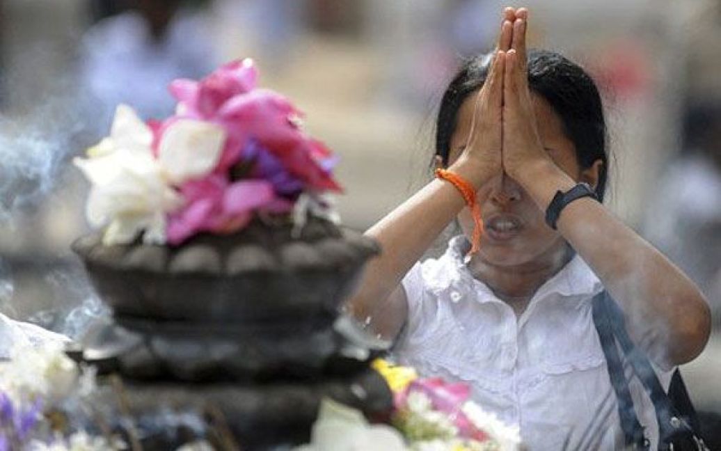 Шрі-Ланка, Келані. Шрі-ланкійська буддійська віддана молиться під час святкування Дня Пойа в храмі Келані. День Пойа є одним з ключових релігійних свят буддистів. / © AFP