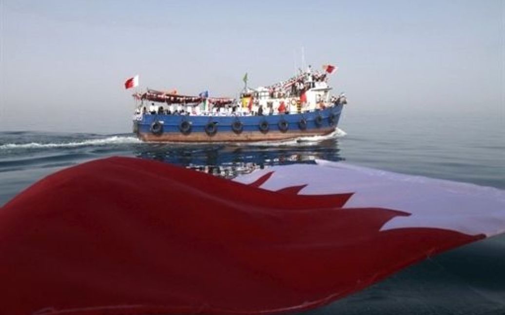 Іран, Даєр. Бахрейнськими прапорами проводжають іранських діячів, які відпливли до порту Даєр на підтримку шиїтських протестів у Бахрейні. Два човни з іранськими "активістами" на борту відправилися в Бахрейн на знак солідарності з протестами проти сунітів. / © AFP