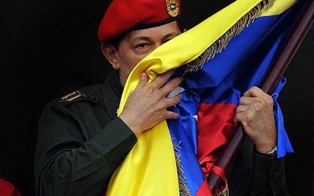 Венесуела, Каракас. Президент Венесуели Уго Чавес цілує венесуельський національний прапор під час виступу у президентському палаці Мірафлорес в Каракасі. Чавес повернувся до Венесуели після трьох тижнів лікування на Кубі, де йому видалили ракову пухлину. / © AFP