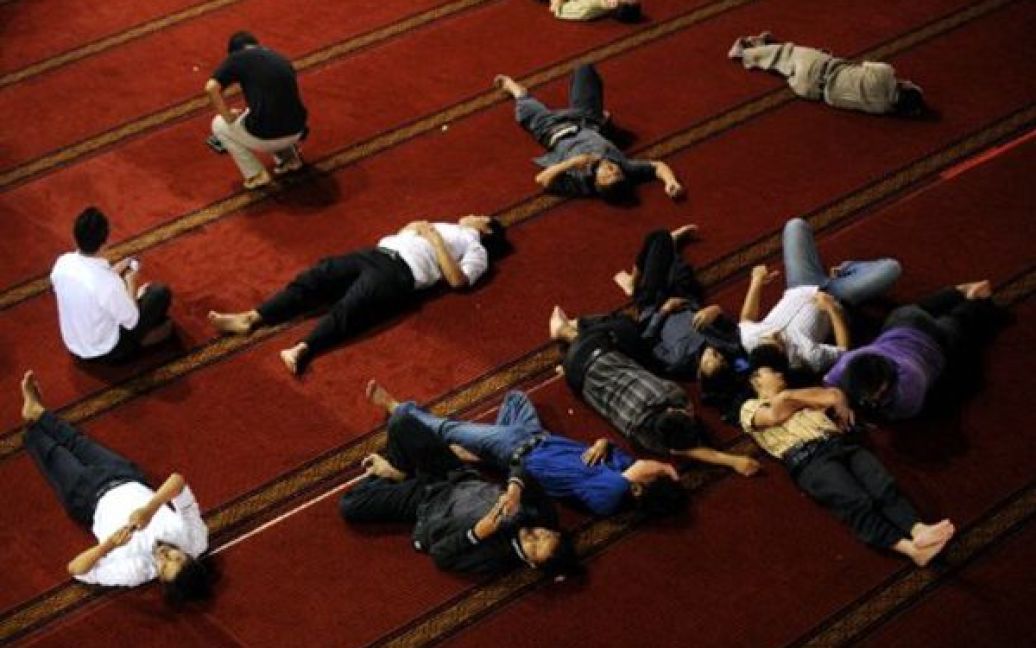 Індонезія, Джакарта. Чоловіки відпочивають перед ранковою молитвою у мечеті. Сьогодні в мусульман розпочався Рамадан. / © AFP