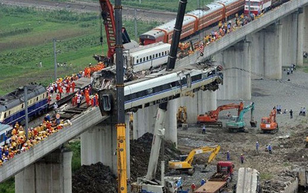 Китай, Сіань. Працівники розчищають уламки після аварії китайського швидкісного потягу, яка сталась в місті Сіань, провінція Чжецзян. В результаті високошвидкісної залізничної катастрофи загинули до 36 осіб, 192 людини отримали поранення. Аварія стала найгіршою на залізницях Китаю з 2008 року. / © AFP