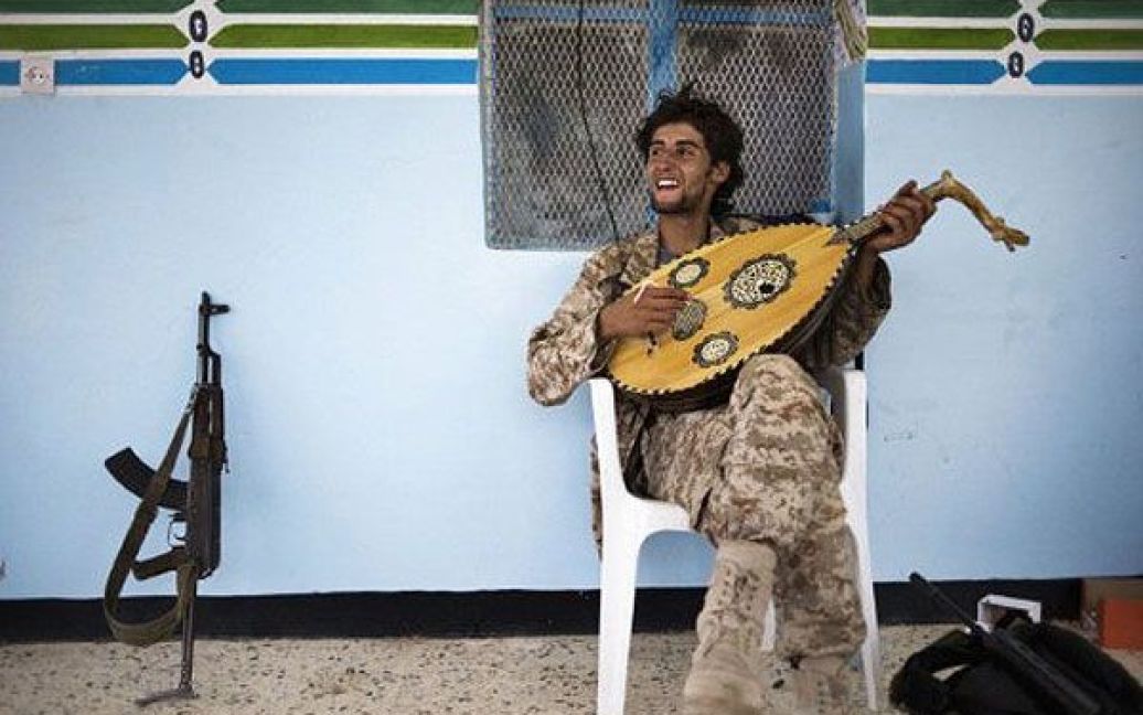 Лівійська Арабська Джамахірія, Газая. Лівійський повстанець грає на традиційному музичному інструменті "уд" після того, як бойовики-повстанці взяли під свій контроль селище Газая. / © AFP