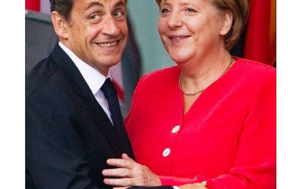 Німеччина, Берлін. Федеральний канцлер Німеччини Ангела Меркель вітає президента Франції Ніколя Саркозі перед канцелярією в Берліні. Лідери Німеччини і Франції зустрілись, щоб обговорити критичні відмінності у новому пакеті порятунку, який Єврозона готує для Греції. / © AFP