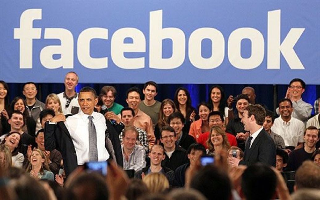 США, Пало-Альто, штат Каліфорнія. Президент США Барак Обама і генеральний директор Facebook Марк Цукерберг вітають глядачів під час наради у штаб-квартирі Facebook, на якій Обама відповідав на економічні питання. / © AFP